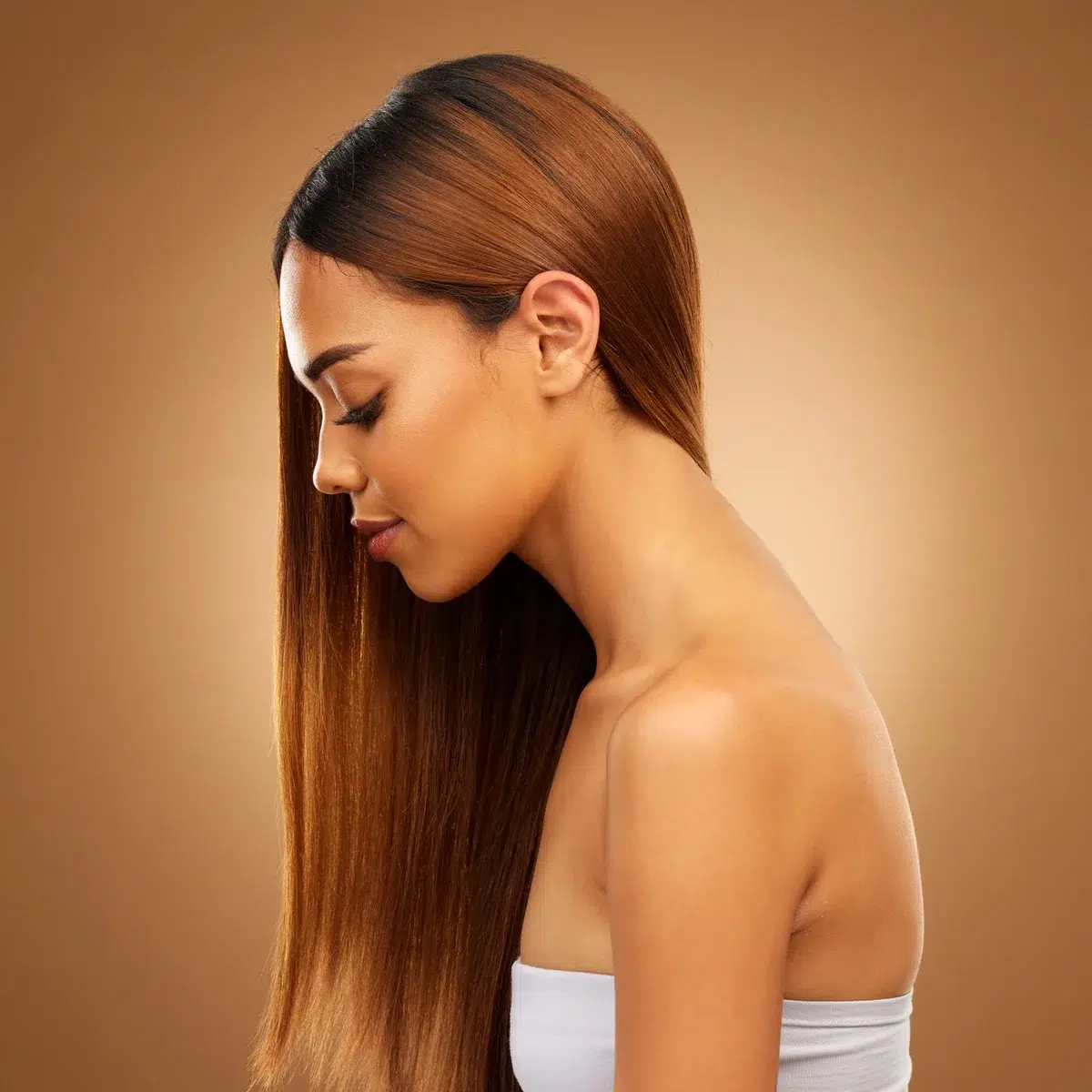 Profil d'une femme avec des cheveux parfaitement lissés, illustrant les résultats d'un lissage à la kératine.