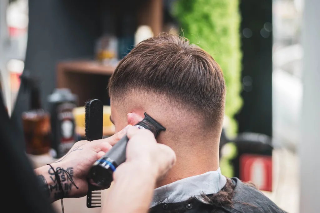 Coiffeur réalisant une wolf cut homme en salon