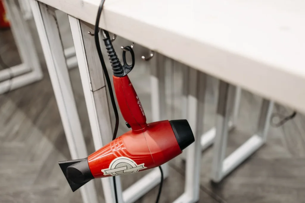 Sèche-cheveux rouge suspendu dans une salle de bains