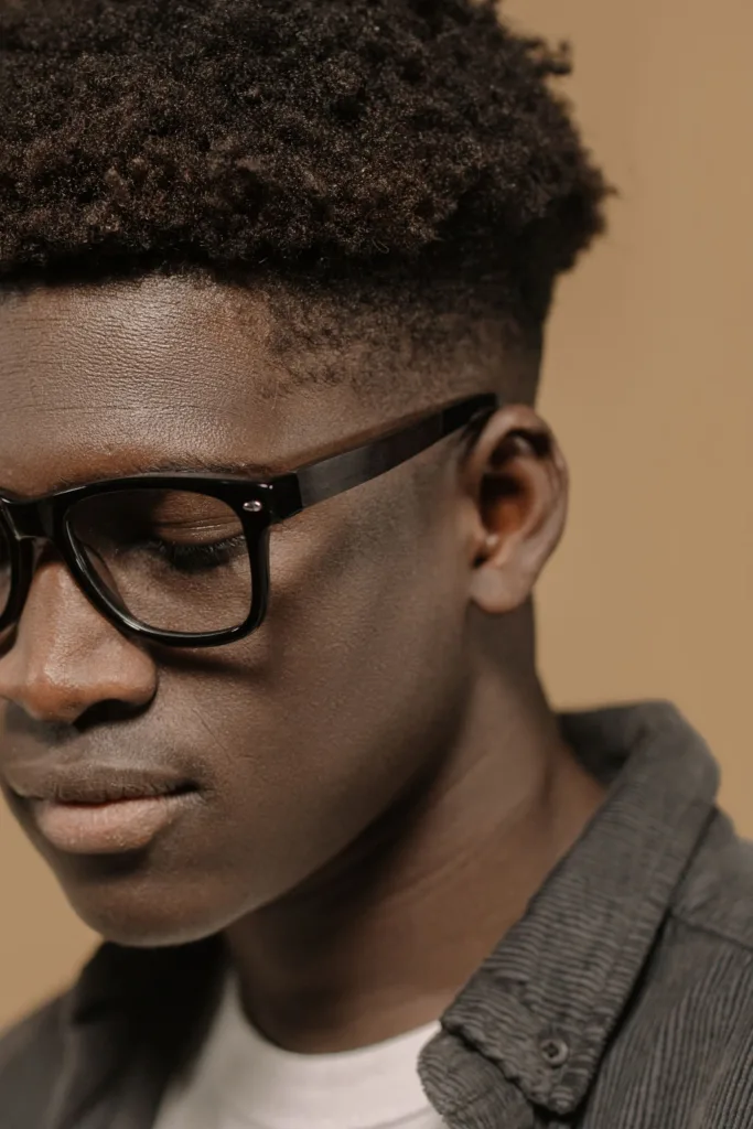 Jeune homme à lunettes avec des boucles courtes texturées à l'éponge