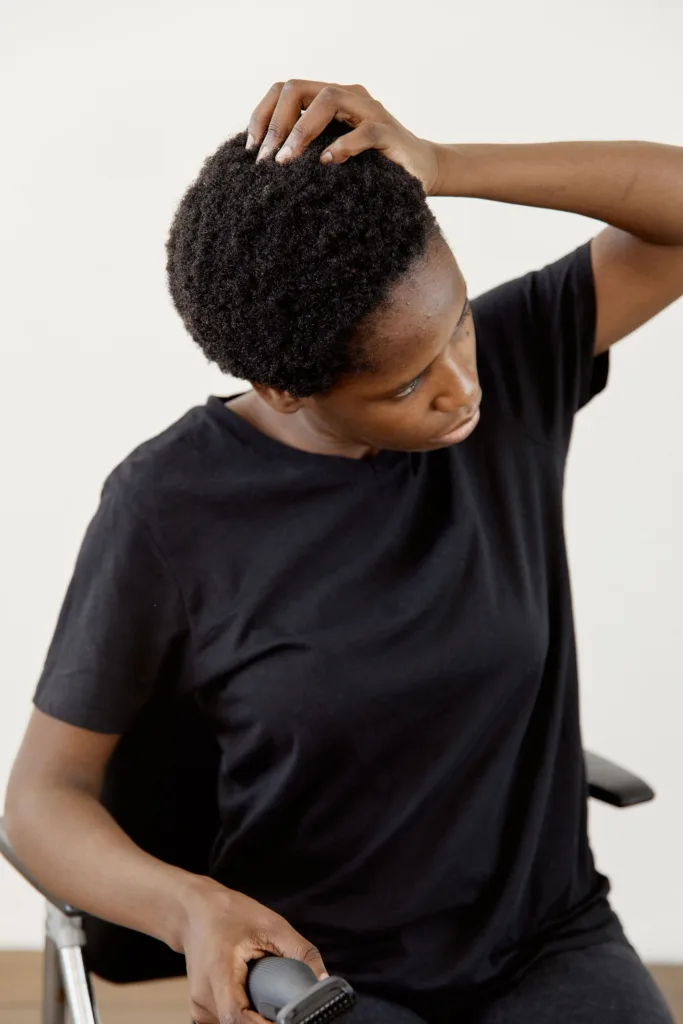 Femme utilisant une tondeuse sur ses cheveux naturels courts