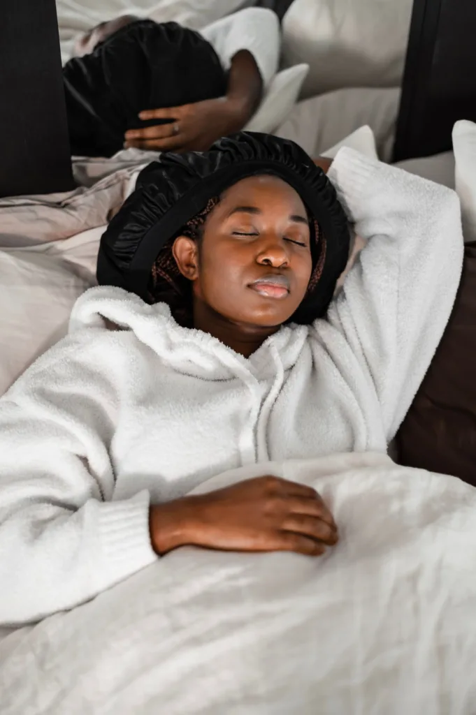 Femme endormie, les cheveux protégés par un bonnet en satin noir