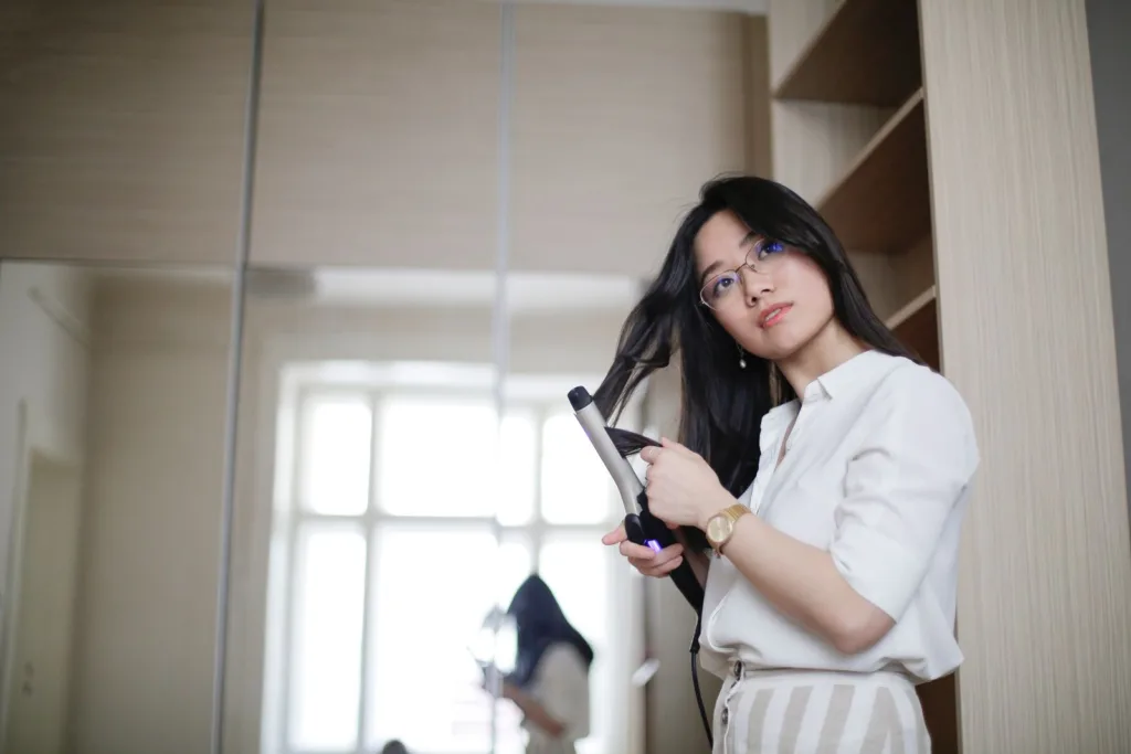 Femme qui boucle ses cheveux chez elle le matin