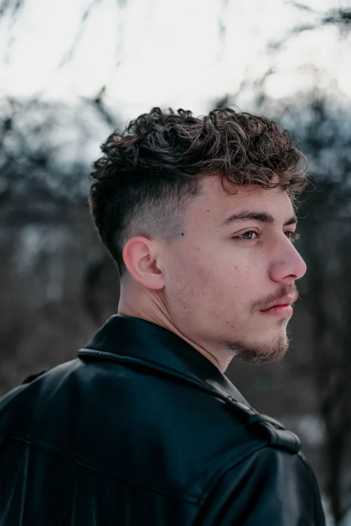 Homme avec des boucles sur le dessus et des côtés dégradés