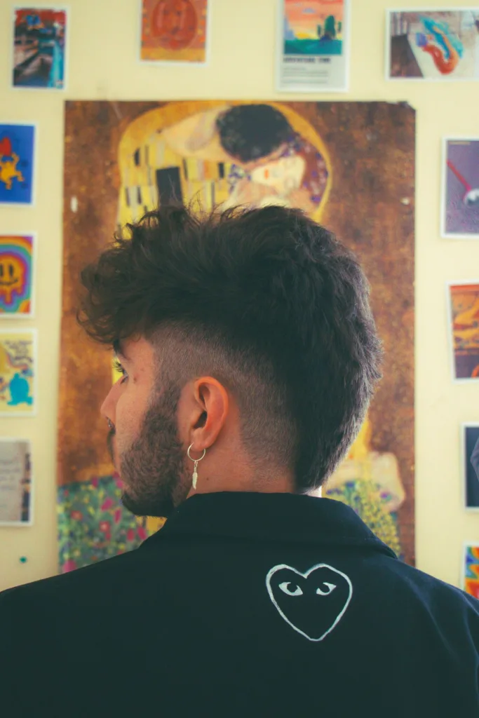 Burst fade mullet vu de dos : dégradé en arc autour de l'oreille, dessus texturé, nuque gardée plus longue