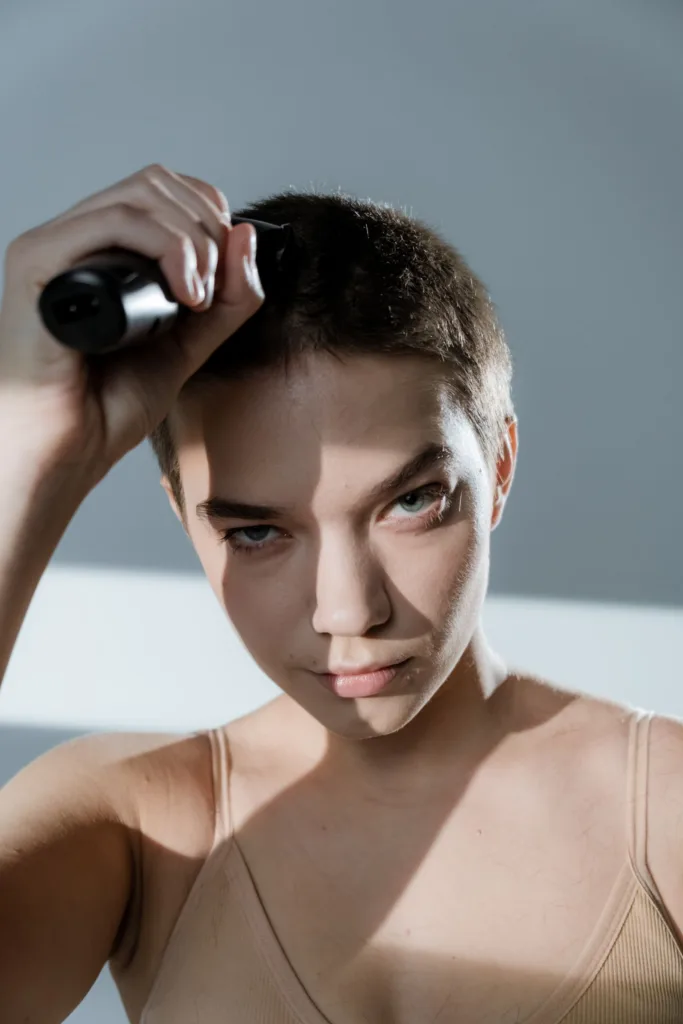 Jeune femme qui se rase la tête à la tondeuse pour un buzz cut