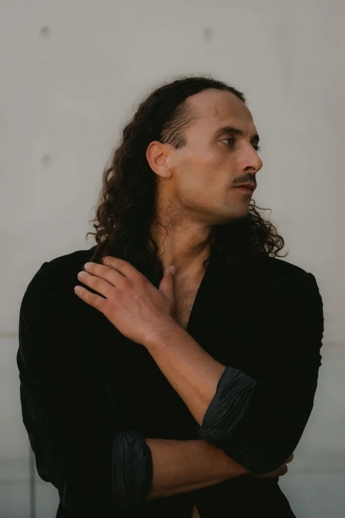 Homme aux cheveux longs bouclés ramenés en arrière