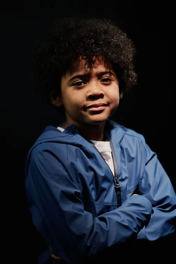 Petit garçon aux cheveux bouclés courts, coupe garçon naturelle vue de face