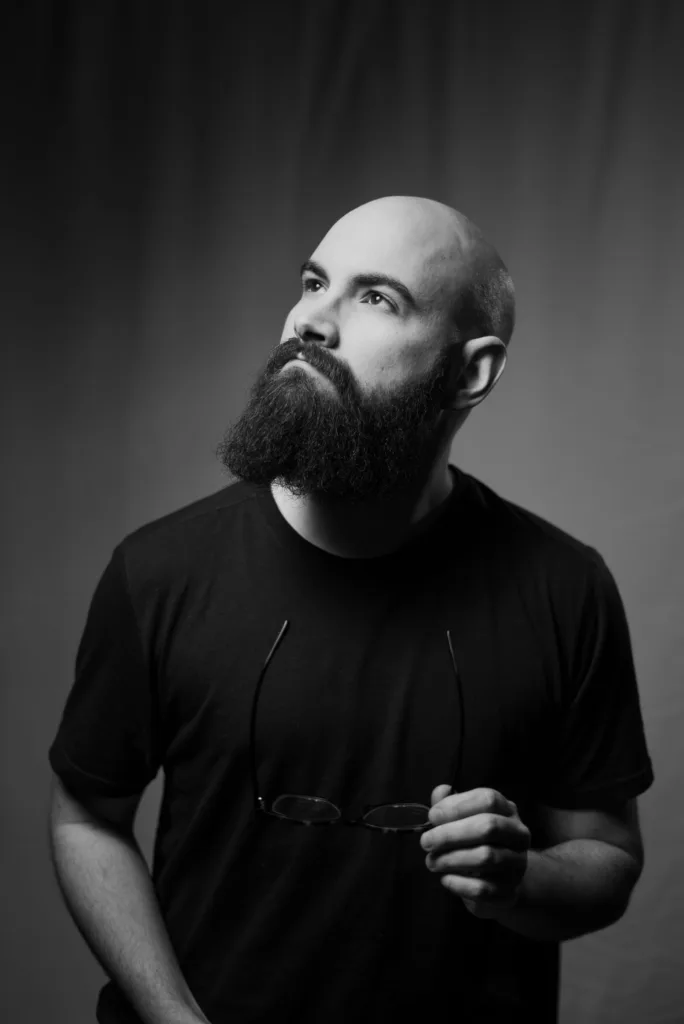 Homme au crâne rasé avec une barbe fournie, photo noir et blanc