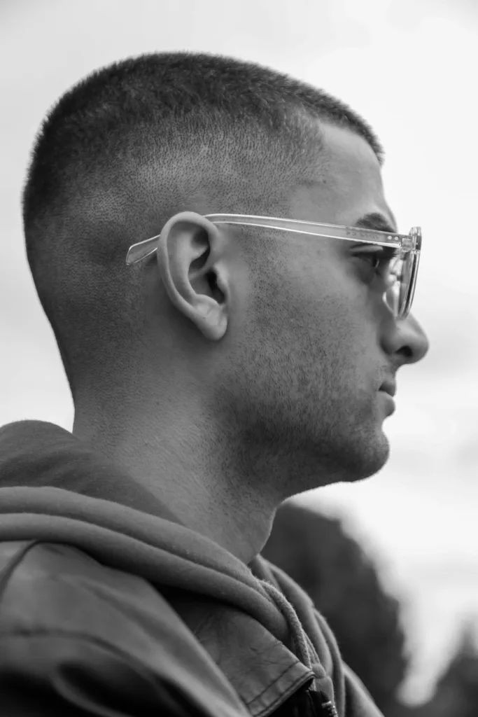 Homme à lunettes avec un crew cut et des côtés dégradés, noir et blanc