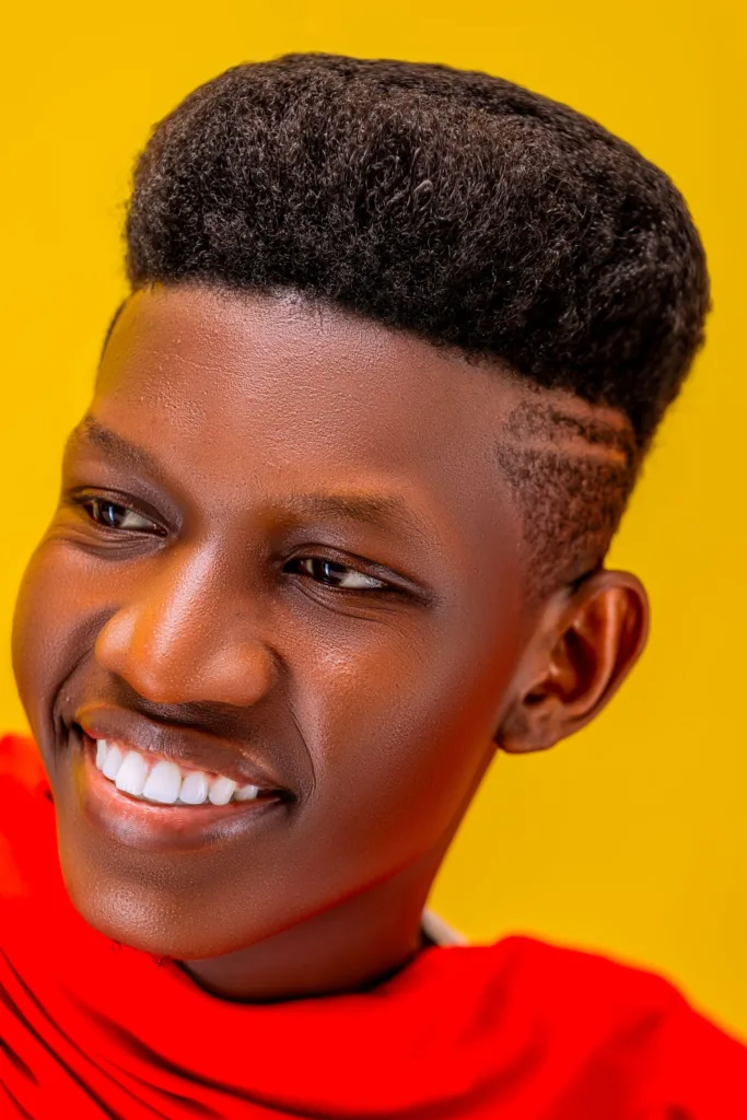 Jeune homme souriant avec une coupe flat top sur cheveux crépus