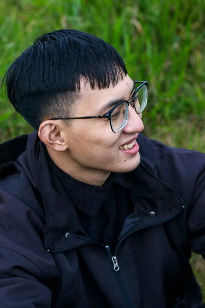 Homme à lunettes avec une frange courte ramenée vers l'avant