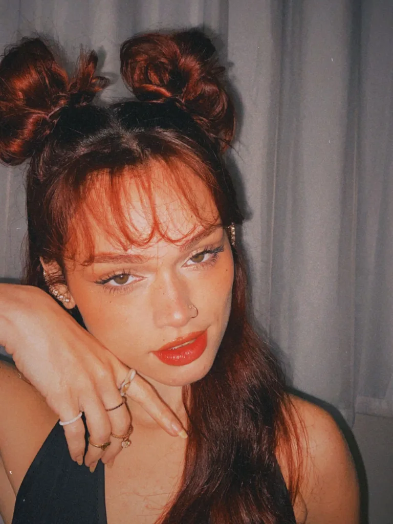 Femme rousse avec une frange rideau et deux petits chignons