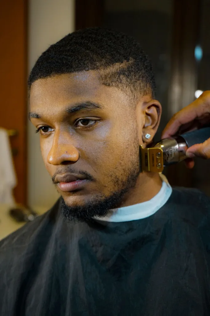 Homme chez le barbier avec un low cut et un taper sur les tempes