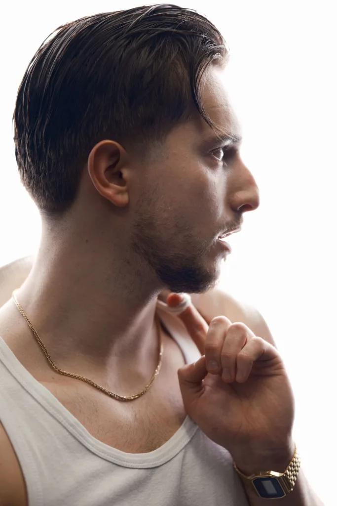 Homme aux cheveux mi-longs coiffés sur le côté avec un dégradé progressif sur les côtés