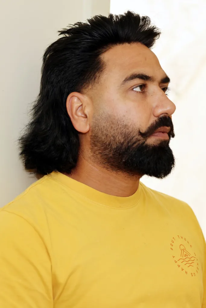 Homme barbu avec un mulet long : côtés courts et longueurs dans la nuque