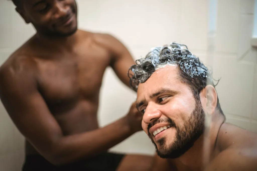 Homme qui se fait masser le cuir chevelu pendant un shampoing