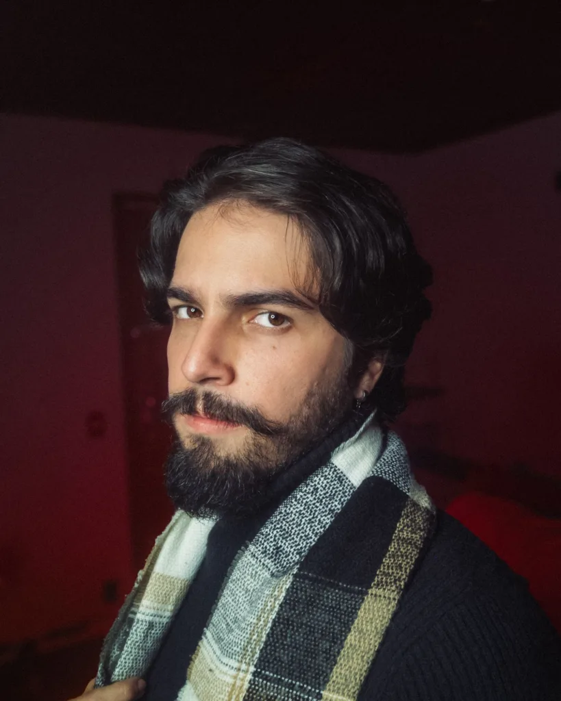 Homme barbu aux cheveux mi-longs plaqués en arrière