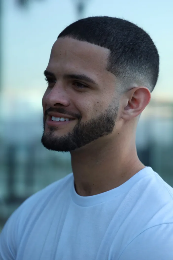 Homme souriant avec un taper fade court et une barbe dessinée