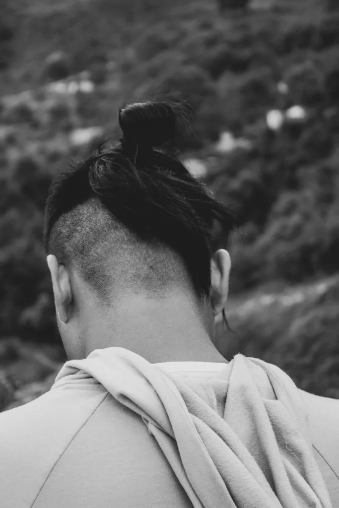 Vue de dos d'un undercut : côtés rasés et longueurs du dessus attachées, noir et blanc